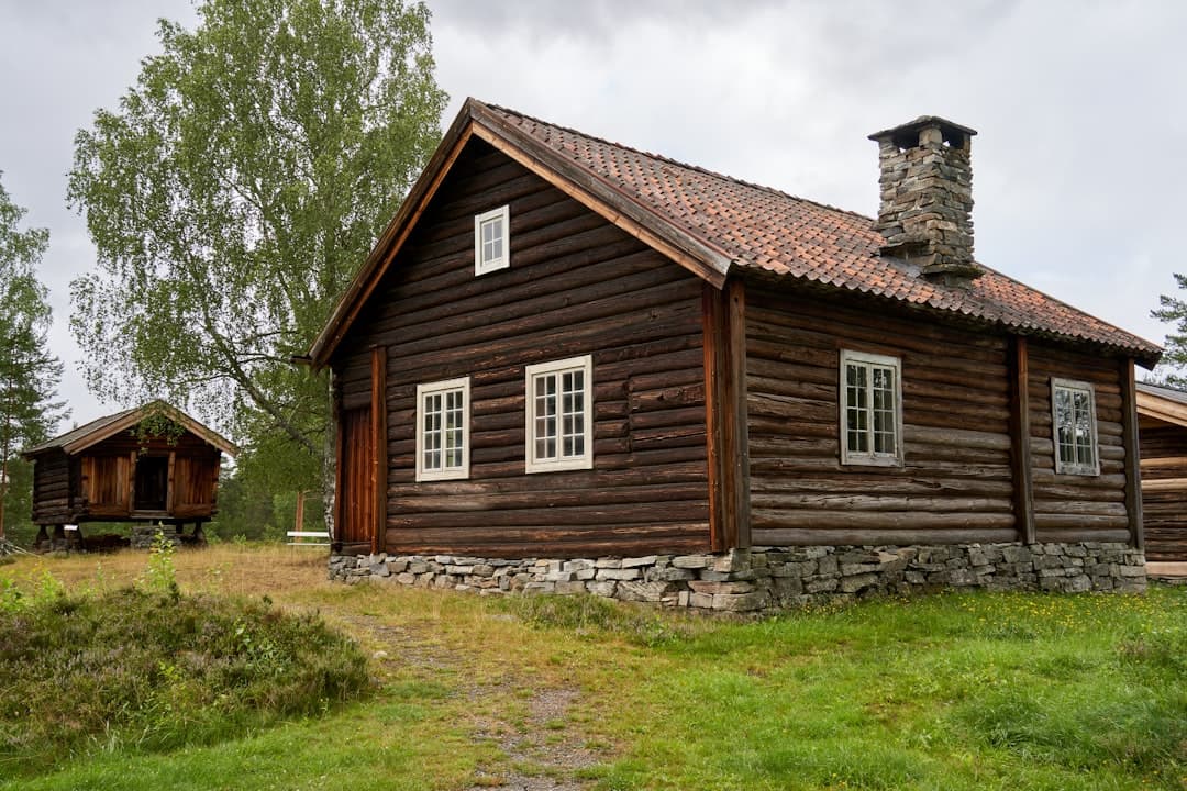 Mörkt timrat hus med flera fönster — exempel på montage i traditionell träfasad