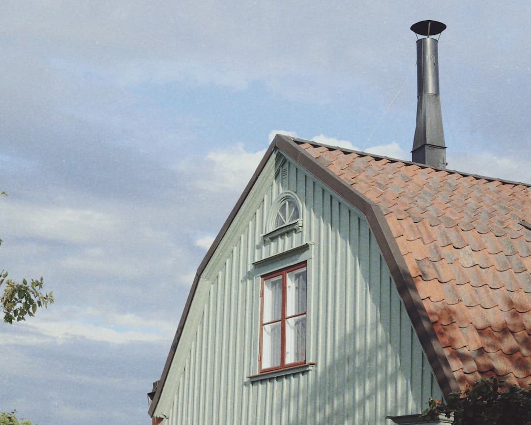 Ljusblått trähus med tegeltak och gavelfönster