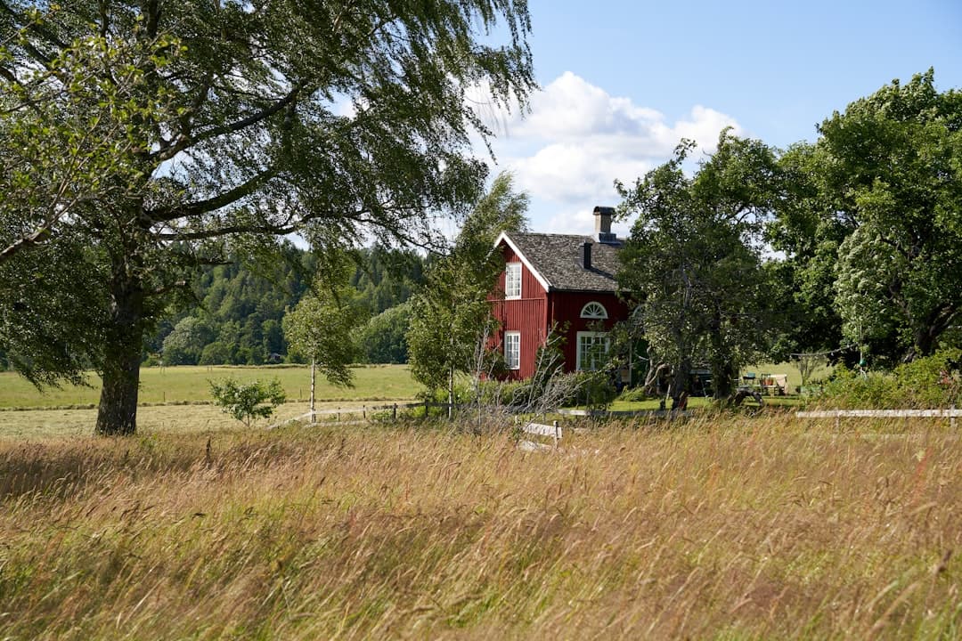 Liten röd stuga i hagmark — typisk dalsländsk miljö