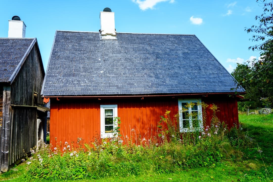 Röd faluröd stuga med vita fönster