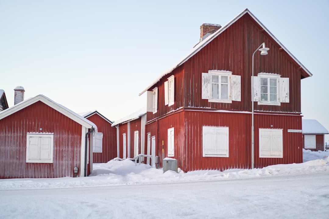 Röda trähus med vita fönster i ett vintrigt svenskt landskap